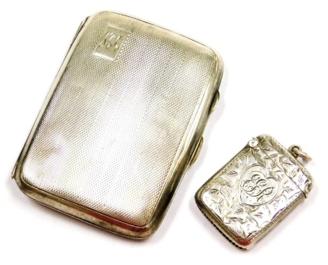 A George V silver cigarette case, with engine turned decoration, rectangular reserve monogram engraved, Birmingham 1935, together with an Edward VII silver Vesta case, with foliate engraving, heart shaped reserve monogram engraved, Chester 1906, 1.95oz. (