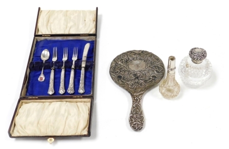 A group of small silver, to include an Edward VII cut glass silver topped scent bottle, of globular form, the lid repousse decorated with scrolls and flowers, lacking stopper, Birmingham 1902, 11cm high, a silver backed hand mirror (AF), silver and enamel