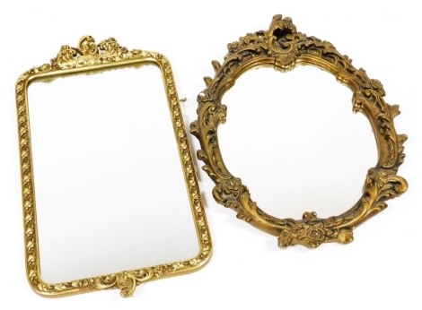 A 20thC gilt framed wall mirror, decorated to top and bottom with scrolls around a twisted border, 71cm high, together with a further gilt framed wall mirror. (2)