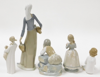 Five Lladro style porcelain figures, comprising figure of a female water carrier, 40cm high, child reading, child holding lamb, child holding doll, and figure of a girl seated. - 2