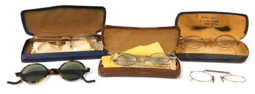 A group of early 20thC spectacles, to include a pair of gold tone rimmed spectacles, cased pince-nez, simulated tortoiseshell rimmed sunglasses, etc. (a quantity)