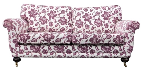 A Laura Ashley two seater sofa, upholstered in purple and cream floral fabric, raised on fluted legs, brass capped on castors, 200cm wide.