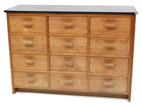 An early 20thC and later oak chest of twelve drawers, 81cm high, 114cm wide, 36.5cm deep.