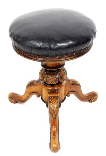 A Victorian mahogany rise and fall piano stool, with an overstuffed leatherette seat, above a foliate and lappet carved column, over three leaf carved cabriole legs, 47cm high.