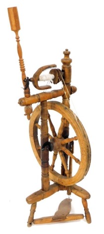 A 19thC oak and fruit wood spinning wheel, 117cm high.