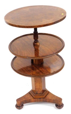 A Victorian walnut rise and fall dumbwaiter, with three circular tiers, raised on a hexagonal column, over a triform base on carved bun feet, 112cm high, 56cm wide.