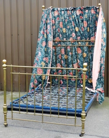 A Victorian brass framed half tester double bed, with floral fabric drapes, bed base and side bars.