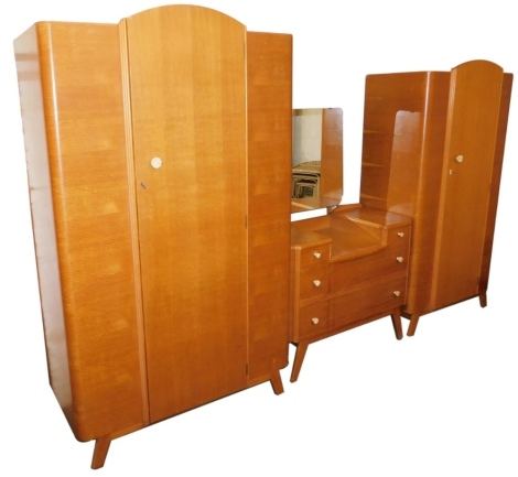 A mid century oak three piece bedroom suite, comprising gentleman's and lady's wardrobes, and a mirror back dressing table, with simulated ivory carved flower handles.