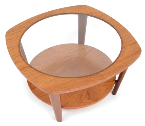 A vintage teak coffee table, the top inset with circular glass, raised on turned legs united by a circular under tier, 37.5cm high, 69cm diameter.