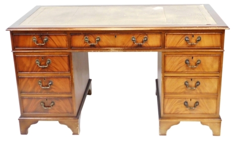 A flame mahogany twin pedestal desk, with a tooled brown leather top over one long and eight short drawers, raised on bracket feet, 77cm high, 137cm wide, 69cm deep.