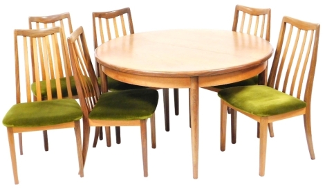 A set of six G-Plan teak single dining chairs, upholstered in green draylon, raised on tapering square legs, together with a G-Plan circular draw leaf dining table, raised on turned legs, 71cm high, 122cm diameter, 168cm extended.