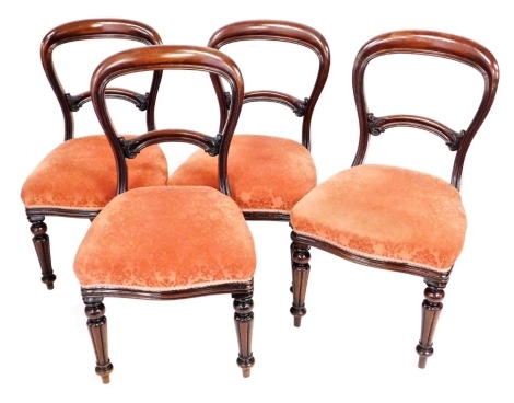 A set of four Victorian mahogany balloon back single chairs, with overstuffed red draylon seats, raised on fluted and turned legs.