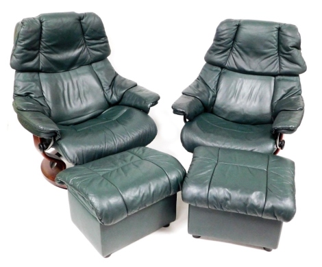 A pair of Ekornes Stressless green leather armchairs, together with matching footstools.