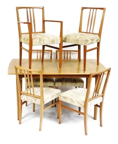 A Gordon Russell of Broadway teak dining table and six chairs, the table with draw leaf, raised on turned legs, 75cm high, 142cm wide, 174cm extended, 84cm deep, and five single dining chairs and a carver.