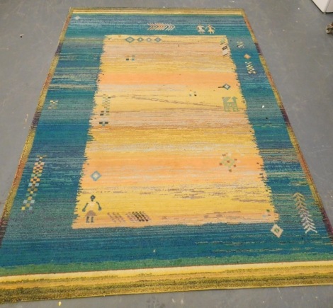 A Caucasian yellow and blue ground rug, decorated with stylised figures, animals, etc., 276cm x 201cm.