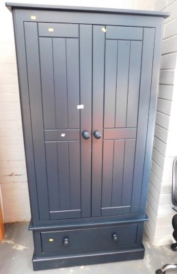 A modern dark blue double wardrobe, the top with a moulded edge above two panelled doors, the base with a single drawer on a plinth base, 180cm high, 92cm wide, 54cm deep. Lots 1501 to 1553 are available to view and collect at our additional premises SALE