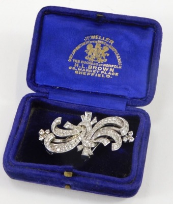 An Art Deco style diamond set clip brooch, consisting of two tied ribbon shapes, with detachable bar, with a white metal joining pin, set with one hundred and twenty round brilliant cut diamonds, ranging in size from 1.5mm to 3mm, and a group of baguette - 3