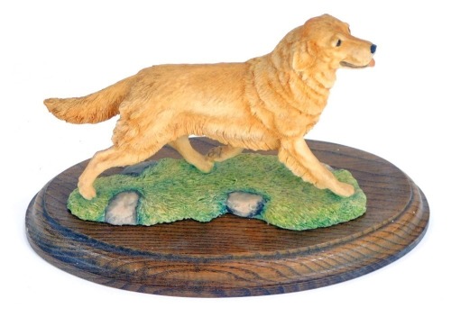 A Border Fine Arts figure of a Golden Retriever, on a turned oak base, stamped BFA Scotland 1982, 17cm high, 21cm wide.