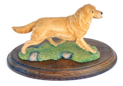 A Border Fine Arts figure of a Golden Retriever, on a turned oak base, stamped BFA Scotland 1982, 17cm high, 21cm wide.