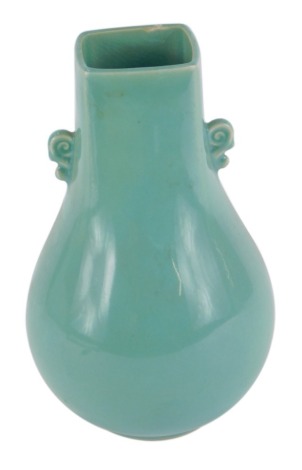 A Chinese celadon glazed vase, with rectangular top on bulbous base, with two scroll handles, 23cm high.