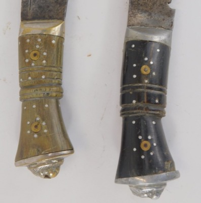 Two Eastern Kukris, each with a curved blade and horn handle, one black, one brown, with inlays and lion's mask terminal, 37cm long. (2) - 2