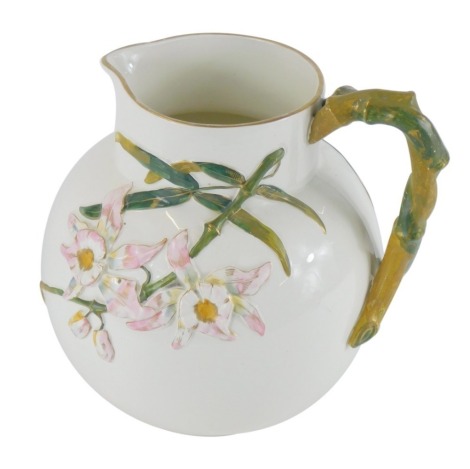 A late 19thC George Jones pottery jug, on a cream body with a bamboo moulded handle, and raised relief of pink flowers, stamped Ivory SJD Bodle, registration lozenge, 24cm high.