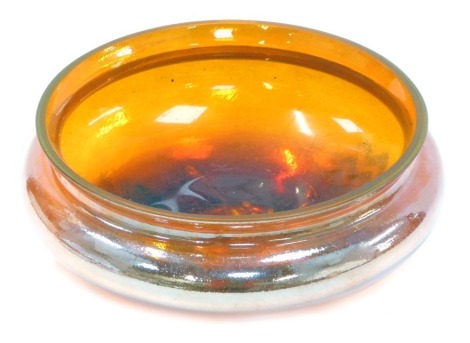 A mid to late 20thC Art Glass bowl, with iridescent orange finish, with swirl and scroll design base, 12cm high, 26cm diameter.