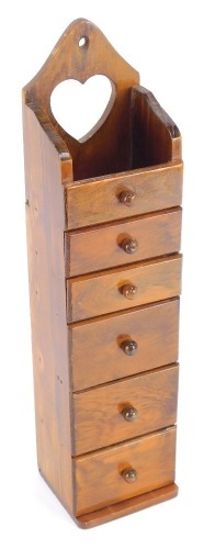 A yew wood hanging spice chest, with a heart crest top, and single shelf above arrangement of five drawers, 42cm high, 10cm wide, 9cm deep.