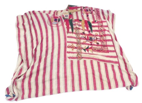 An early 19thC North African coloured linen tribal robe, of striped design, with pink striping and embroidery, 120cm high, 80cm wide. (AF)