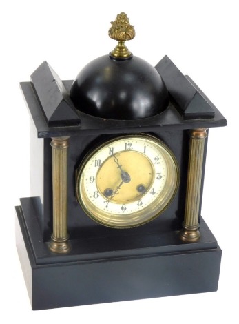 A Victorian black slate mantel clock, with a domed and turreted gilt top, with two column supports, with a brass dial, enamel chapter ring bearing Arabic numerals, eight day movement with coil strike, with pendulum, no key, 33cm high, 22cm wide, 15cm deep