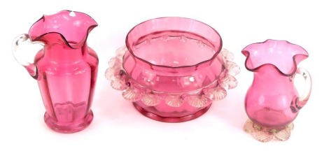 Three items of Victorian Cranberry glass, comprising two cream jugs, 13cm and 10cm high, and a fluted bowl, 9cm high. (3)