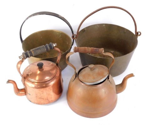 A group of copper and brass wares, comprising two copper jam pans, 32cm diameter and 24cm diameter, and two copper kettles. (4)