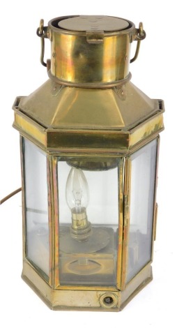 A 19thC brass ship's lantern, with flat back and a shaped front, with wooden swing handle, converted to electricity, 41cm high, 20cm wide, 14cm deep.