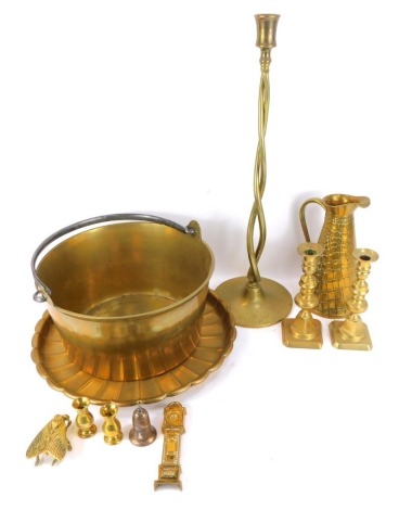 A group of Victorian and later brasswares, comprising a fluted charger, 41cm wide, a double spiral candlestick, 60cm high, a pair of brass candlesticks, 19cm high, a simulated skin finish jug, and a preserve pan with swing handle, 33cm high. (a quantity)