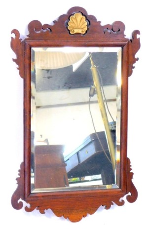 A Georgian mahogany fret framed wall mirror, with shell gilt moulded top, inset bevelled glass, 67cm high, 43cm wide.