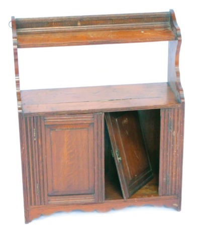 A Victorian mahogany hanging cupboard, with a raised gallery top, above single shelf with two cupboard doors on reeded supports, 74cm high, 58cm wide, 23cm deep.