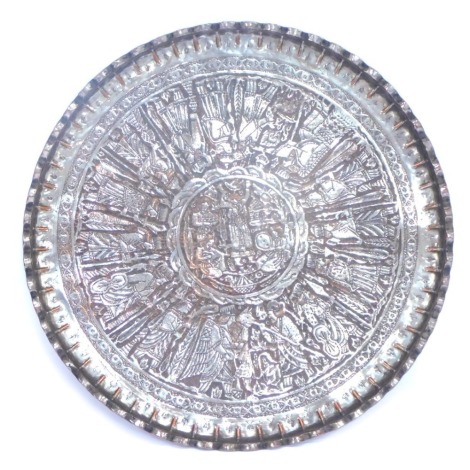 An Eastern hammered white metal tray, depicting warriors, with a fluted border, 67cm diameter.