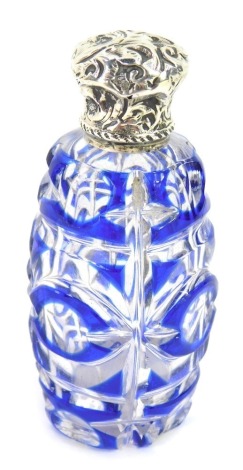 A Victorian cut glass and silver topped scent bottle, with blue and clear flash glass, and a foliate scroll silver top, unmarked, 7cm high.