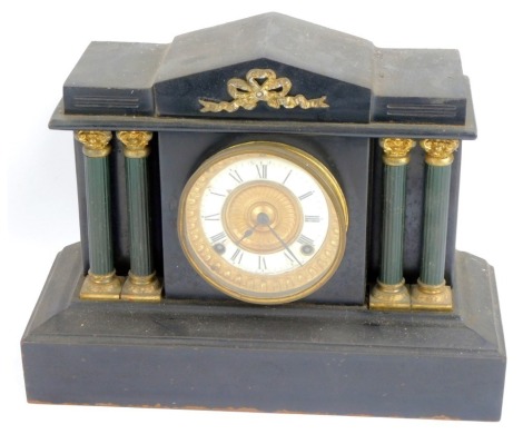 A Victorian black slate mantel clock, with an arched top with applied brass bow, with four column supports, a white enamel Roman numeric chapter ring, Ansonia Clock Company eight day movement with coil strike, with pendulum, no key, 29cm high, 35cm wide, 