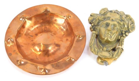 An Arts and Crafts hammered copper bowl, 21cm wide, and a brass Dionysus door knocker, 17cm high. (2)