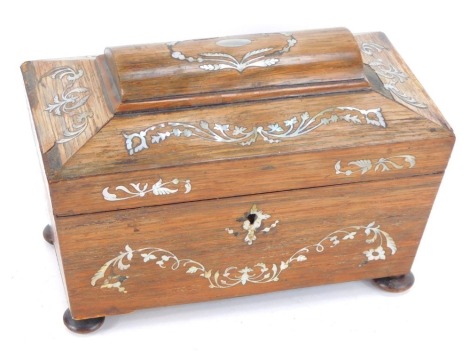 A Regency rosewood and mother of pearl inlaid tea caddy, of sarcophagus form, opening to reveal two lidded compartments, raised on bun feet, 17cm high, 26cm wide, 14cm deep. (AF)