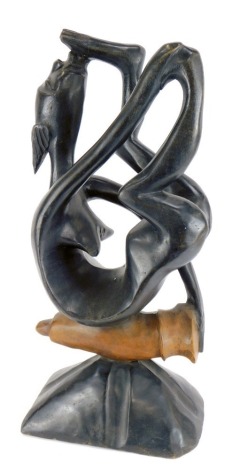 Tribal art. A carved wooden fertility figure of a female kissing her foot, raised on a phallus, above a rock base, 63cm high.