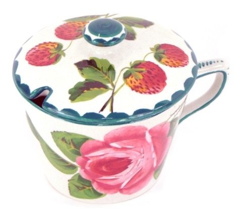 A Wemyss pottery tea cup, decorated with cabbage roses, painted mark, together with a preserve pot lid painted with strawberries. (2)