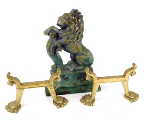 A Victorian brass door stop, cast as a rampant lion, 32cm high, and two brass andirons, 20cm diameter. (3)