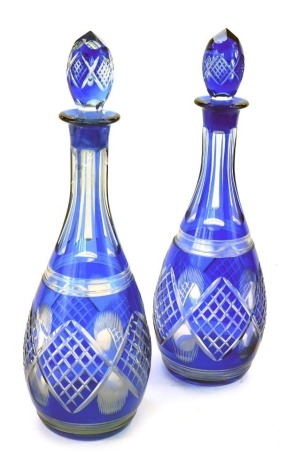 A pair of early 20thC blue flashed glass decanters and stoppers, 36cm high. (AF)