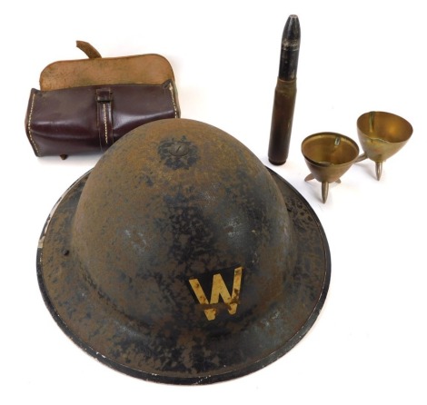 A WWII metal Air Warden's helmet, 26cm diameter, a military bandage and case, two converted shell case cap salts, 6cm high, and a empty cartridge, 18cm high. (5)