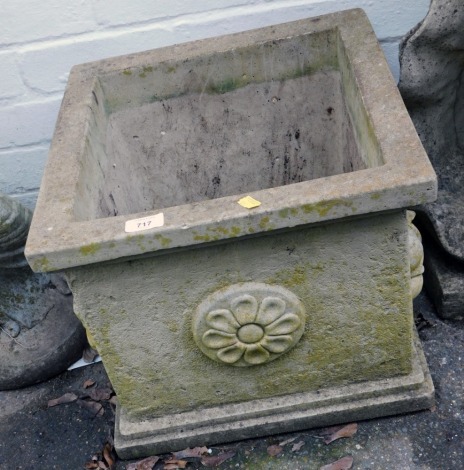 A reconstituted stone square planter, with a ribbed border and floral panels, 36cm high, the top 40cm x 40cm.