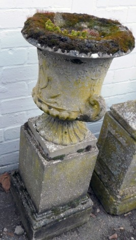 A reconstituted stone campana urn planter, the campana top with figure of female, on a circular base, raised on a square plinth, 90cm high.