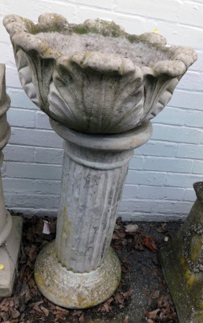 A reconstituted stone bird bath, with leaf moulded top, on a fluted column support, 90cm high, 47cm diameter.