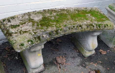 A reconstituted stone garden bench, with curved seat, on scroll supports, 44cm high, 93cm wide, 40cm deep.